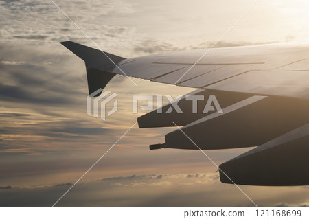 view of airplane wing during flight in sunset view of airplane wing during flight in sunset 121168699