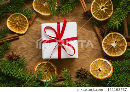 Christmas background top view with fir branches on wood background with present box Christmas background top view with fir branches on wood background with present box 121168787