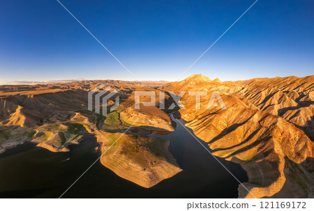 Panoramic aerial view on picturesque Azat reservoir and Eranos mountain at bright sunny evning sunset. Lake with blue water in arid area and Yeranos mountains range. Beautiful landscape. Armenia. 121169172