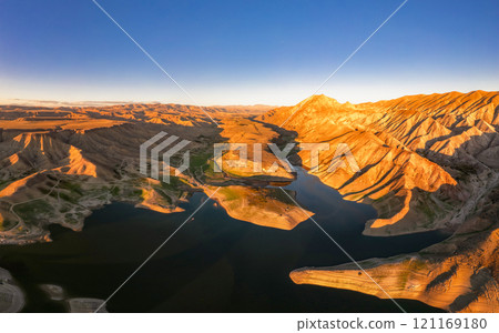 Panoramic aerial view on picturesque Azat reservoir and Eranos mountain at bright sunny evning sunset. Lake with blue water in arid area and Yeranos mountains range. Beautiful landscape. Armenia. Panoramic aerial view on picturesque Azat reservoir and Eranos mountain at bright sunny evning sunset. Lake with blue water in arid area and Yeranos mountains range. Beautiful landscape. Armenia. 121169180