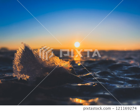 Frosty air and frozen lake surface in a beautiful sunset landscape. Beautiful ice shapes and sunlight. Photo from Sotkamo, Finland. 121169274