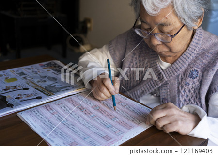 查看目錄並訂購產品的高級女性 121169403