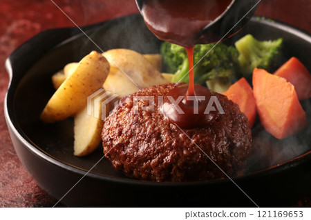 Juicy and delicious looking hamburger steak served on a plate or grilled on a hot plate 121169653