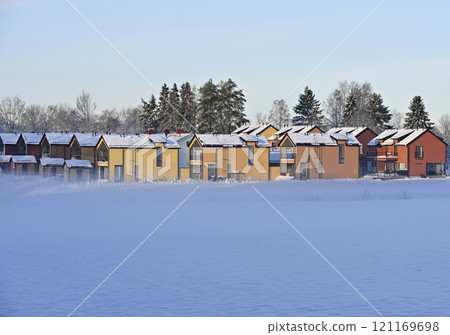 a row of colorful houses in a snowy winter landscape 121169698