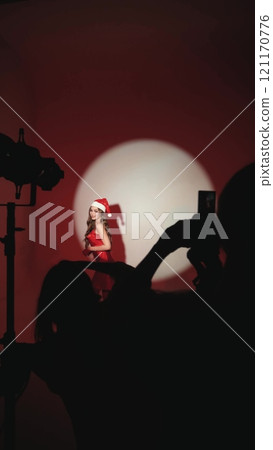 Sexy happy woman with long hair in New Year's hat and red dress posing on white background at New Year's party style photo shoot Sexy happy woman with long hair in New Year's hat and red dress posing on white background at New Year's party style photo shoot 121170776