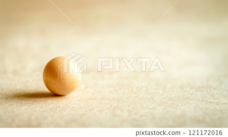 Small smooth wooden bead resting on light background 121172016