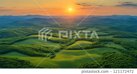 Golden sunrise over rolling green hills and mountains surrounded by lush forests 121172472