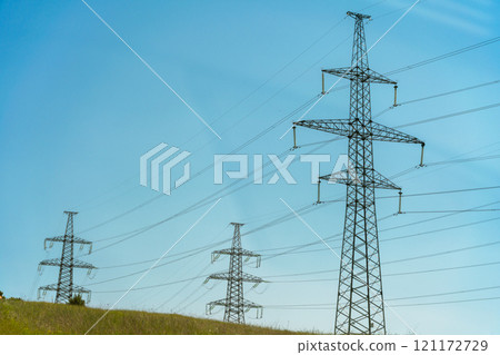 High voltage towers with sky background. Power line support with wires for electricity transmission. High voltage grid tower with wire cable at distribution station. Energy industry, energy saving High voltage towers with sky background. Power line support with wires for electricity transmission. High voltage grid tower with wire cable at distribution station. Energy industry, energy saving 121172729
