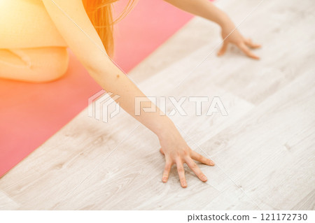 Girl does yoga. Young woman practices asanas on a beige one-ton background. 121172730