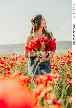 Woman poppies field. portrait happy woman with long hair in a poppy field and enjoying the beauty of nature in a warm summer day. 121172731