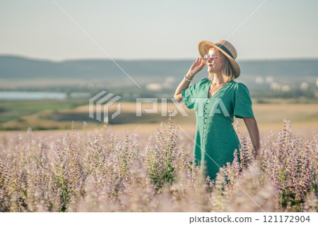 Woman Dress Field: Summer Fashion Photo Shoot; Blond woman in teal dress enjoys a sunny day in a lavender field. Woman Dress Field: Summer Fashion Photo Shoot; Blond woman in teal dress enjoys a sunny day in a lavender field. 121172904