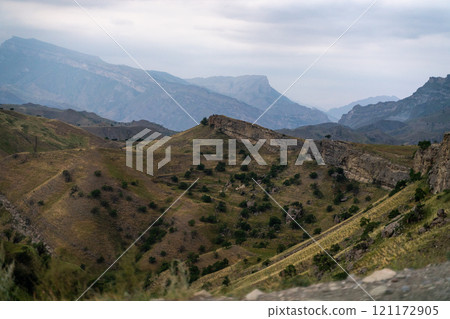 The mountains are covered in trees and grass, and the sky is cloudy The mountains are covered in trees and grass, and the sky is cloudy 121172905