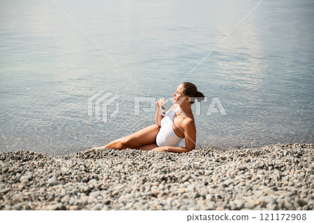 Freelance close up woman hands writing on computer. Well looking middle aged woman typing on laptop keyboard outdoors with beautiful sea view. 121172908