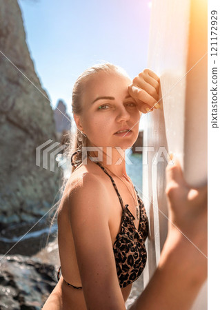 Woman sup sea travel in black bikini. Portrait of a happy girl on the background of a surfboard in the sea on a sunny summer day 121172929