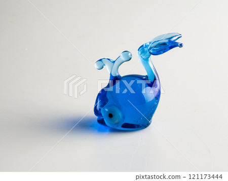 A figurine of a blue whale, specially made of glass on a white background. A figurine of a blue whale, specially made of glass on a white background. 121173444