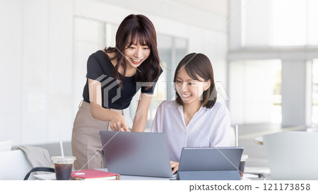 Two women/businesswomen working on a computer Two women/businesswomen working on a computer 121173858
