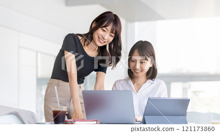 Two women/businesswomen working on a computer Two women/businesswomen working on a computer 121173860