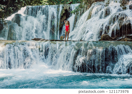 Woman on cascade waterfalls with blue water in Luwuk, Central Sulawesi Woman on cascade waterfalls with blue water in Luwuk, Central Sulawesi 121173976