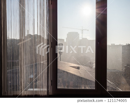 view through window of apartment on city in smog 121174005
