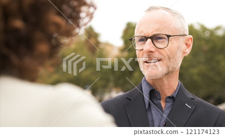 Confident businessman talking with female colleague in city 121174123