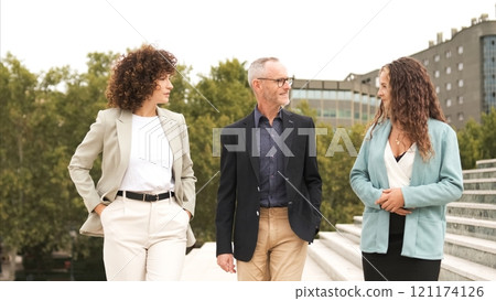 Confident business coworkers discussing near stairs in city Confident business coworkers discussing near stairs in city 121174126