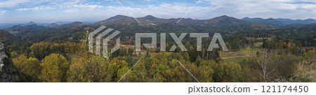 Wide panoramic view from viewpoint Stredni vrch near Dolni Prysk, Ceska Kamenice. Autumn landscape with colorful forest, hills and blue cloudy sky in Luzicke hory Lusatian Mountains, Czech Republic. 121174450