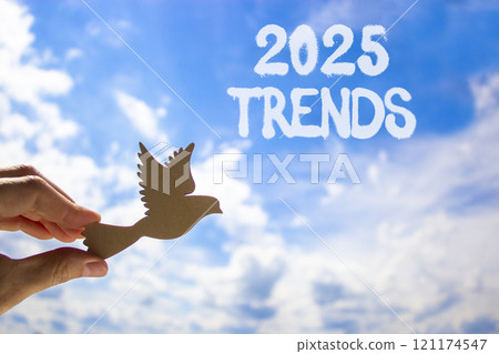 Planning 2025 trends new year symbol. Concept words 2025 Trends on beautiful blue sky. Beautiful blue sky clouds background. Hand holds wooden bird. Business 2025 trends new year concept. Copy space. Planning 2025 trends new year symbol. Concept words 2025 Trends on beautiful blue sky. Beautiful blue sky clouds background. Hand holds wooden bird. Business 2025 trends new year concept. Copy space. 121174547