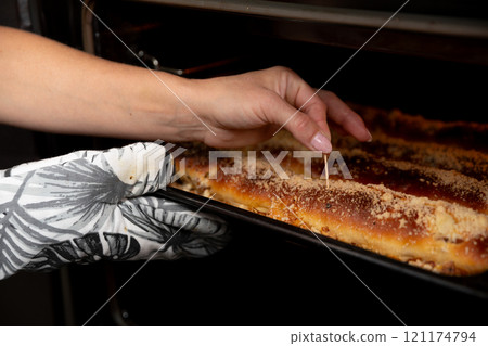 Carefully Checking the Perfectly Baked Dish with a Toothpick to Ensure its Just Right Carefully Checking the Perfectly Baked Dish with a Toothpick to Ensure its Just Right 121174794