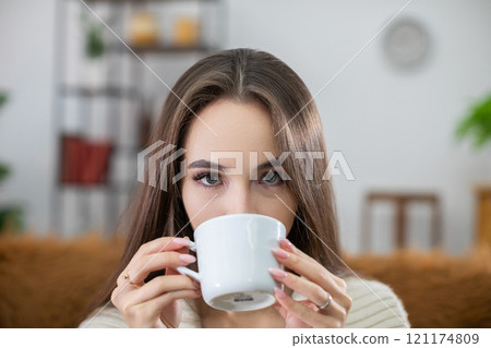 Cozy Moment A Young Woman Savoring Her Coffee in a Chic and Stylish Setting Nearby Cozy Moment A Young Woman Savoring Her Coffee in a Chic and Stylish Setting Nearby 121174809