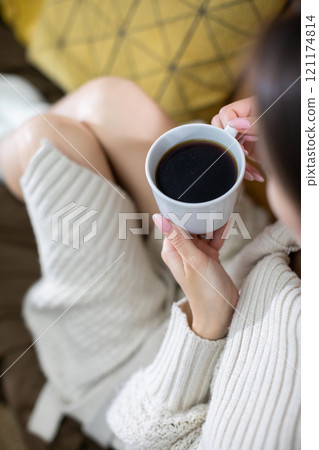 Embracing a Cozy Coffee Moment While Wearing a Soft Knit Sweater on a Relaxing Afternoon Embracing a Cozy Coffee Moment While Wearing a Soft Knit Sweater on a Relaxing Afternoon 121174814