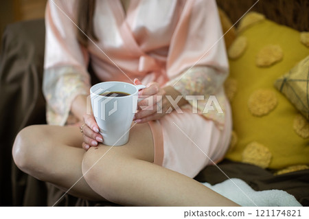 Enjoying a cozy morning with a warm cup of coffee while lounging in comfy pajamas at home Enjoying a cozy morning with a warm cup of coffee while lounging in comfy pajamas at home 121174821