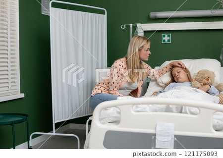 A Caring Mother Comforting Her Child Lying in a Hospital Bed Filled with Love and Compassion 121175093