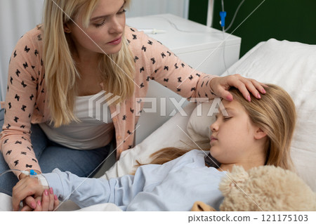 Tender Care A Loving Mother Comforts Her Sick Daughter in the Hospital Room Today Tender Care A Loving Mother Comforts Her Sick Daughter in the Hospital Room Today 121175103