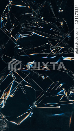 Creased film overlay. Distressed foil. Plastic wrap. Blue orange white color glitch scratches light flare wrinkled dust texture dark black illustration art abstract background. 121175324