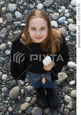 Happy child girl eating ice cream outdoors, top view 121175576