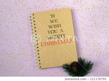 Minimalistic holiday message in a golden notebook and festive decor 121176793