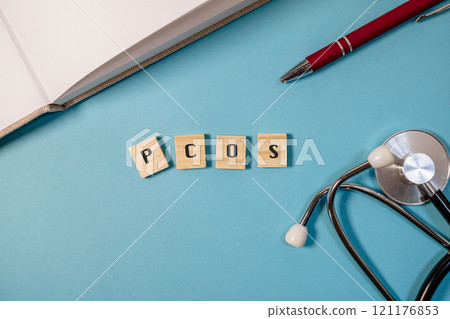 Pen and a book with the word PCOS written on it 121176853