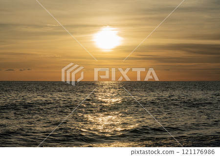 Sunset Over the Ocean With Golden Reflections Casting Serene Ambiance 121176986