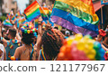 Crowd celebrating with rainbow flags at a public event 121177967