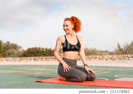 Happy sporty woman sitting in Vajrasana posture on 121178862