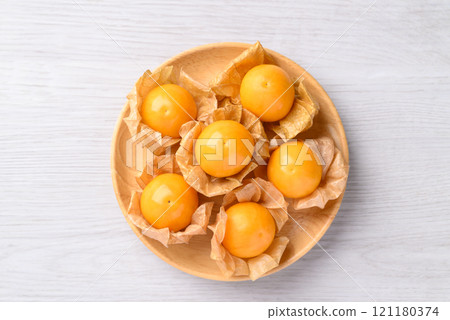 Cape gooseberry, Golden berry (Physalis peruviana) in wooden bowl on white background 121180374