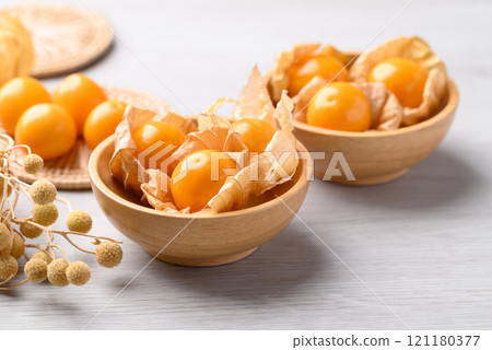 Cape gooseberry or Golden berry (Physalis peruviana) in wooden bowl on white background 121180377