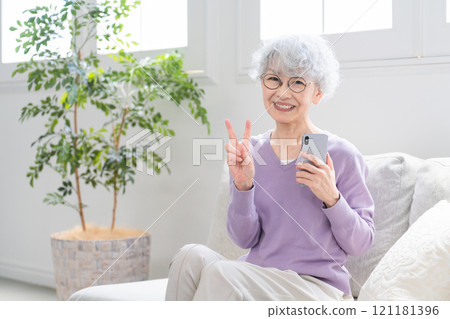 Senior woman holding a smartphone 121181396
