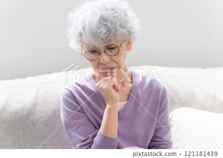 坐在沙發上的老年婦女 坐在沙發上的老年婦女 121181439