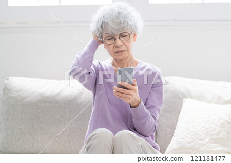 Senior woman operating a smartphone 121181477