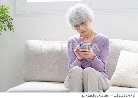 Senior woman operating a smartphone 121181478