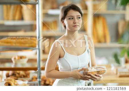 Girl choosing fresh baked goods on display in private bakery 121181569