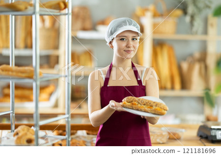 Young woman chef of pastry shop demonstrates product of assortment, bocadillo on disposable plates Young woman chef of pastry shop demonstrates product of assortment, bocadillo on disposable plates 121181696
