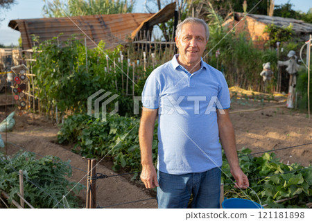 Portrait of elderly positive man on his farm on summer day Portrait of elderly positive man on his farm on summer day 121181898