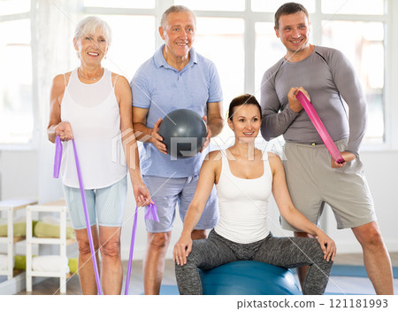 Group of men and women posing with pilates equipment Group of men and women posing with pilates equipment 121181993